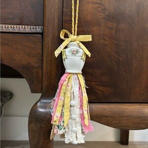 Repurposed vintage salt shaker and repurposed clothes used as tassels.